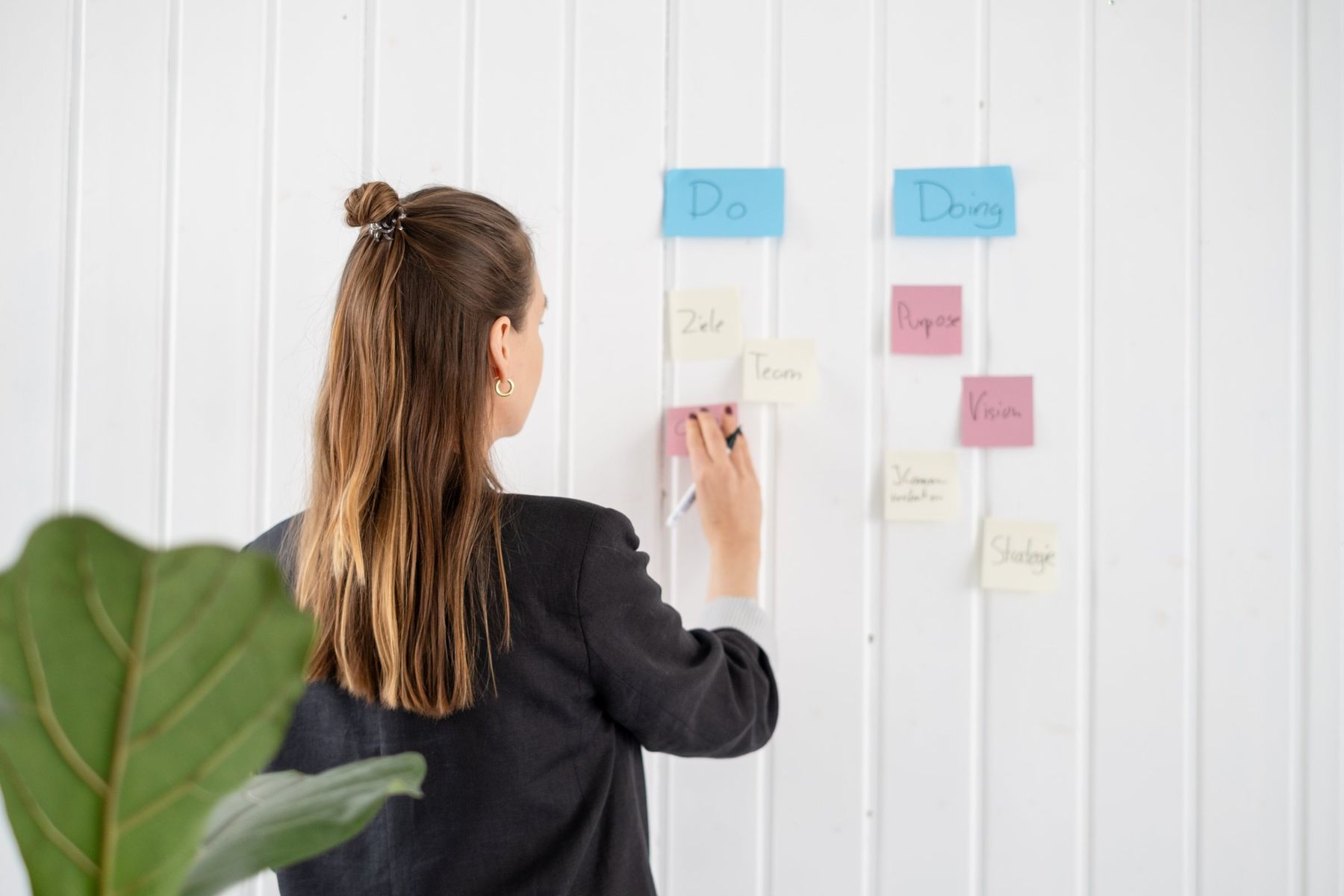 Johanne Heck-Parsch ordnet Post-its an einer Wand